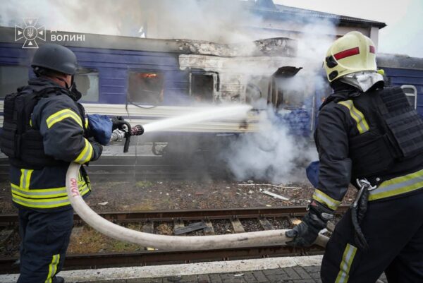 Dieses vom ukrainischen Katastrophenschutzdienst am 13. September 2026 veröffentlichte Foto zeigt Feuerwehrleute, die einen durch einen Drohnenangriff nahe der polnischen Grenze beschädigten Zugwaggon mit Wasser besprühen. (Foto: Ukrainischer Katastrophenschutzdienst / AFP)