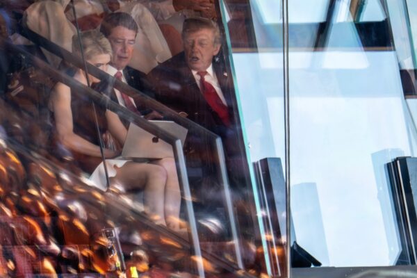 US-Präsident Donald Trump (Republikaner) und US-Senator Bill Hagerty (Republikaner aus Tennessee) betrachten einen Laptop, der von Trumps persönlicher Assistentin Natalie Harp gehalten wird, während sie das Auftaktspiel der Tennessee Volunteers gegen die Texas Longhorns in der Southeastern Conference (SEC) im Neyland Stadium in Knoxville, Tennessee, am 26. September 2026 verfolgen. (Foto: Jim Watson / AFP)