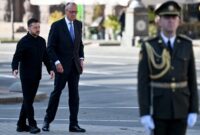 Der ukrainische Präsident Wolodymyr Selenskyj (links) und der deutsche Bundeskanzler Friedrich Merz treffen sich am 4. Oktober 2026 vor einer Zeremonie in der Nähe eines provisorischen Denkmals für ukrainische und ausländische Soldaten auf dem Unabhängigkeitsplatz in Kiew. (Foto: Sergei Supinsky / AFP)
