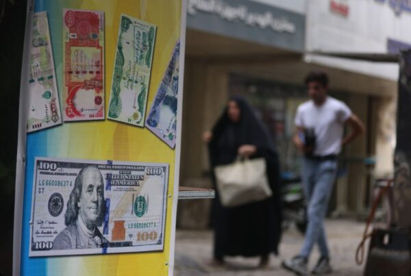 Iraker gehen am 7. Oktober 2026 an einer geschlossenen Wechselstube in Bagdad vorbei. Die irakische Zentralbank hatte am selben Tag den Dinar gegenüber dem Dollar abgewertet, da sich die Krise im Land aufgrund des Nahostkriegs weiter verschärfte. (Foto: AHMAD AL-RUBAYE / AFP)