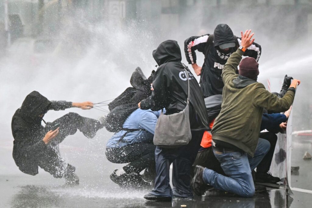 Am Rande einer von Gewerkschaften organisierten Demonstration gegen die Haushaltsmaßnahmen der Bundesregierung in der Nähe des Brüsseler Südbahnhofs am 9. Oktober 2026 wurden Demonstranten mit einem Wasserwerfer beschossen. (Foto: NICOLAS TUCAT / AFP)