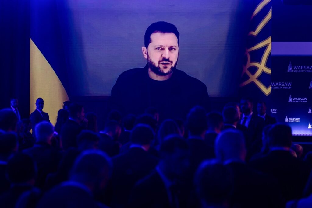Teilnehmer hören zu, wie der ukrainische Präsident Wolodymyr Selenskyj am 12. Oktober 2026 während der Eröffnungssitzung des Warschauer Sicherheitsforums in Warschau, Polen, per Videoschaltung spricht. (Foto: Wojtek Radwanski / AFP)
