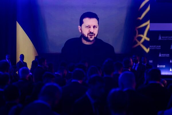 Teilnehmer hören zu, wie der ukrainische Präsident Wolodymyr Selenskyj am 12. Oktober 2026 während der Eröffnungssitzung des Warschauer Sicherheitsforums in Warschau, Polen, per Videoschaltung spricht. (Foto: Wojtek Radwanski / AFP)