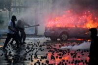Demonstranten werfen am 17. Oktober 2026 in der Innenstadt von Tirana Feuerwerkskörper auf Bereitschaftspolizisten. (Foto: Armend Nimani / AFP)