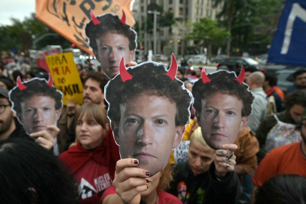 Anhänger des brasilianischen Präsidenten und Präsidentschaftskandidaten Luiz Inácio Lula da Silva hielten am 19. Oktober 2026 vor dem Hauptsitz von Meta in São Paulo Masken mit dem Konterfei von Meta-Chef Mark Zuckerberg und roten Hörnern hoch. (Foto: NELSON ALMEIDA / AFP)