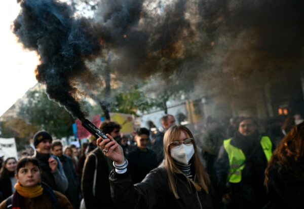 Ein Demonstrant hält eine Rauchfackel während einer Demonstration gegen Budgetkürzungen an Universitäten vor der Technischen Universität Wien in Österreich am 22. Oktober 2026. (Foto: Joe Klamar / AFP)