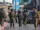 Israelische Soldaten versammeln sich am Ort eines vorangegangenen Feuergefechts zwischen bewaffneten Palästinensern und israelischen Streitkräften nach einem Vorfall am nördlichen Kontrollpunkt von Hebron im israelisch besetzten Westjordanland am 23. Oktober 2026. (Foto: Ahmad Gharabli / AFP)