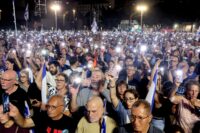 Demonstration auf dem Hostage Square in Tel Aviv am 24. Oktober 2026: Demonstranten halten ihre Handys mit eingeschalteten Taschenlampen hoch und forderten die Einsetzung einer staatlichen Untersuchungskommission zu den Hamas-Anschlägen vom Oktober 2023. (Foto: Jack GUEZ / AFP)